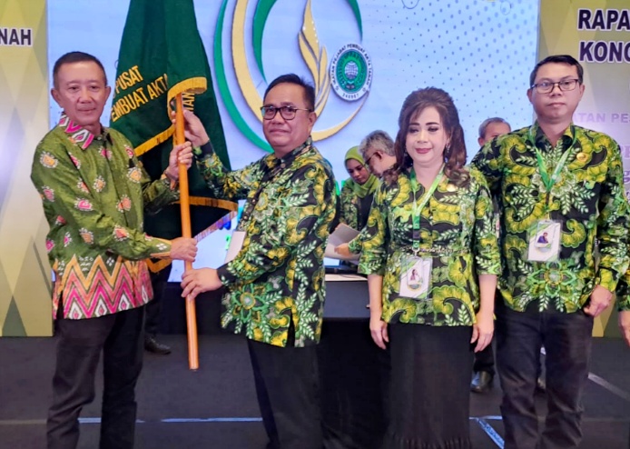 Penyerahan bendera pataka oleh Ketua Umum PP IPPAT Dr. Hapendi Harahap, SH, MH kepada Ketua Pengwil Bali IPPAT I Made Widiada, SH